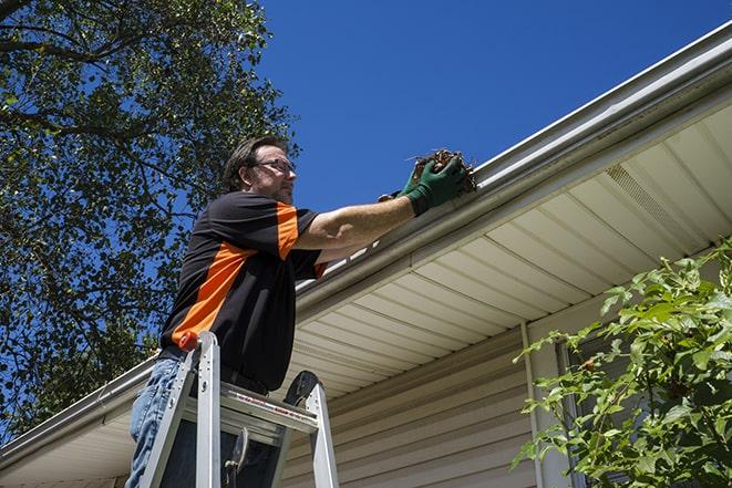 roofing technician replacing a rusted and leaking gutter in Barrington Hills